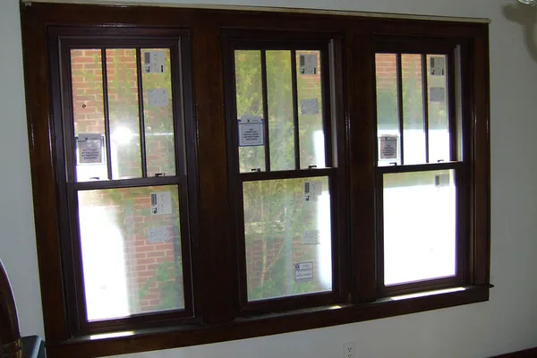 Three new double-hung replacement windows with wood trim